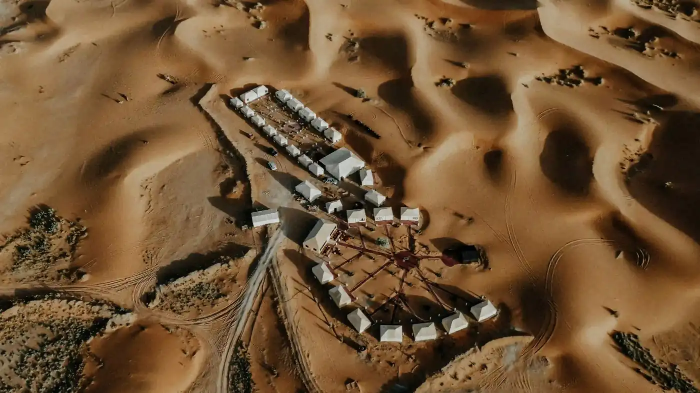 How much does a Morocco desert tour cost — 2026 price guide Aerial view of a luxury Sahara desert camp — what a Morocco desert tour costs in 2026