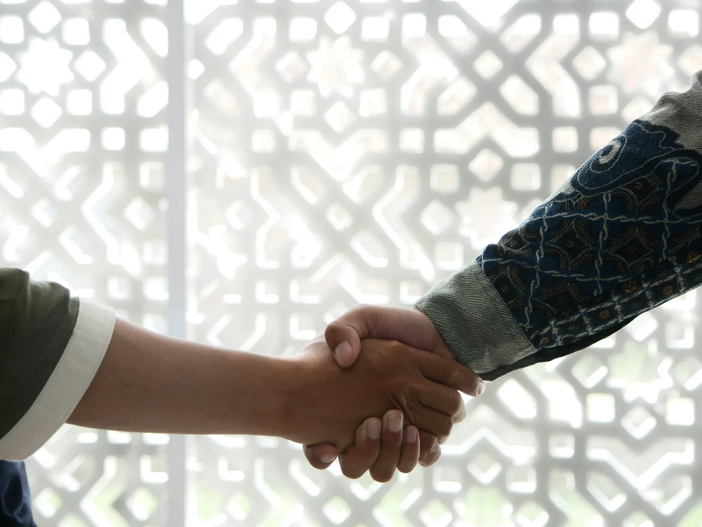 Handshake in front of a carved mashrabiya screen &mdash; a B2B trade partnership agreed directly with the Marrakech ground-handling team, with no broker in between