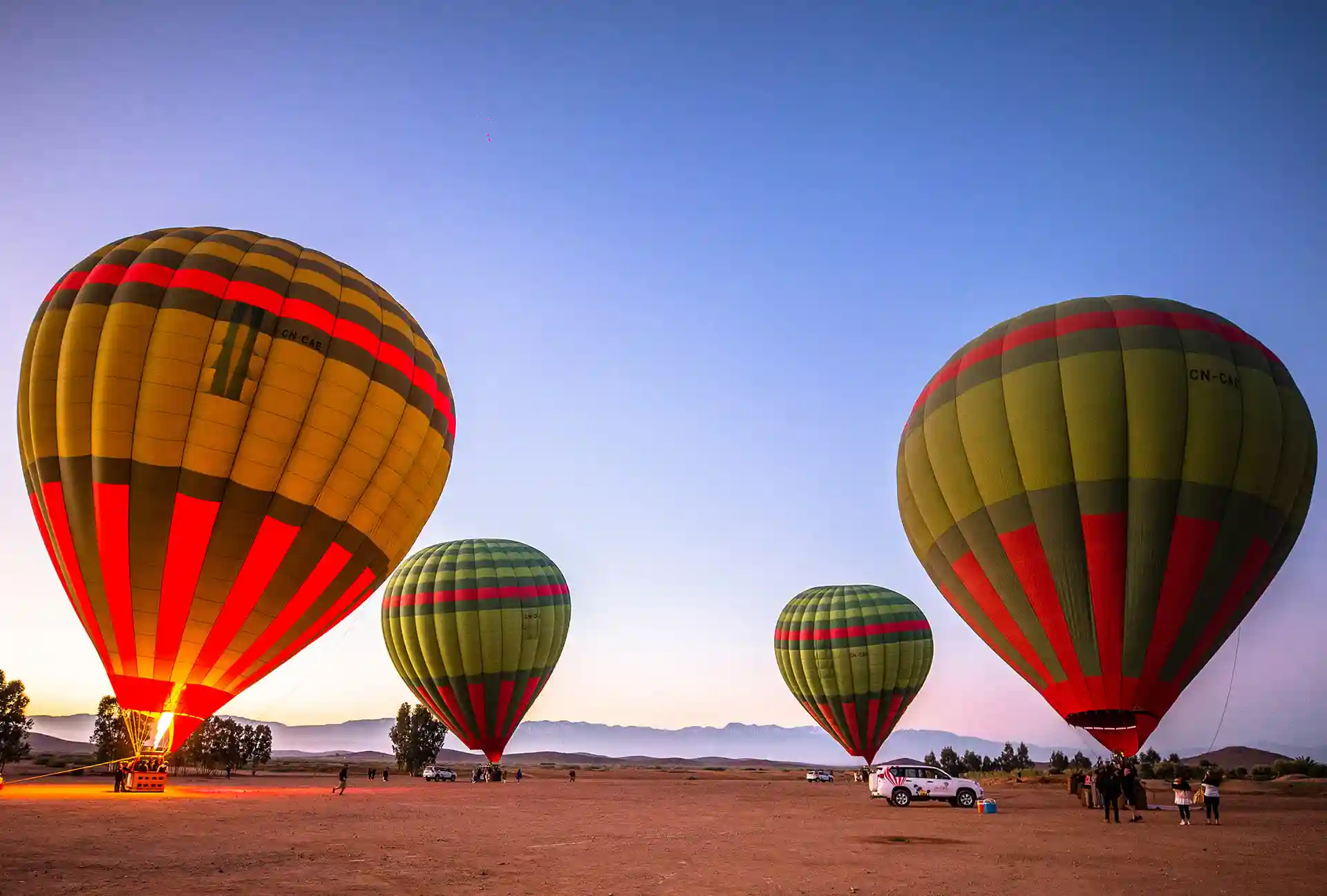 Hot air balloon flight over Marrakech at sunrise — Atlas mountains in the distance