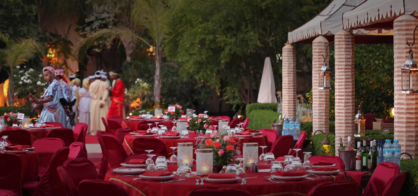 Garden dinner set with decorated tables, lanterns and musicians at a Marrakech venue